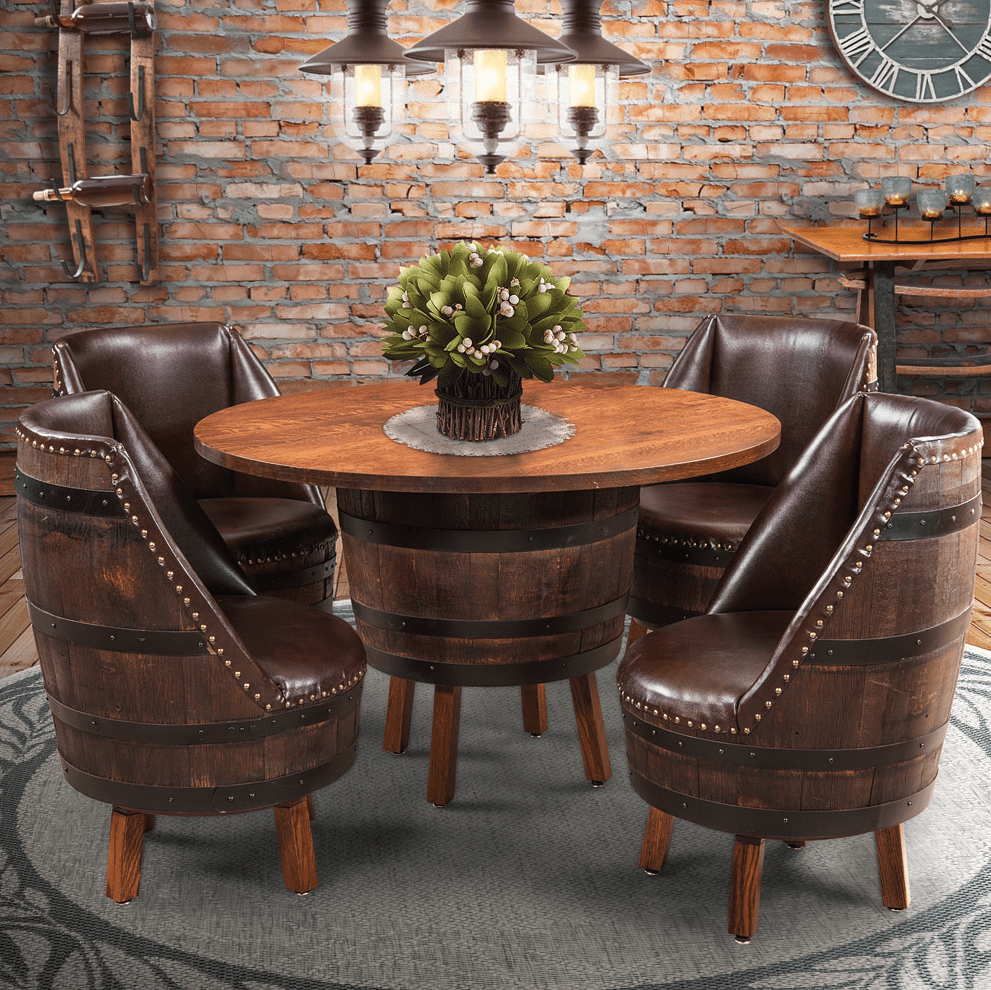 Round barrel dining table with four upcycled barrel armchairs in dark wood and brown leather, set against an exposed brick wall under pendant lights.
