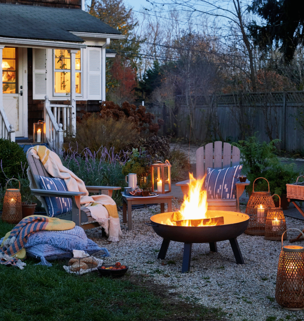 Cozy backyard campfire setup with Adirondack chairs, plaid blankets, glowing lanterns, and a fire pit at dusk