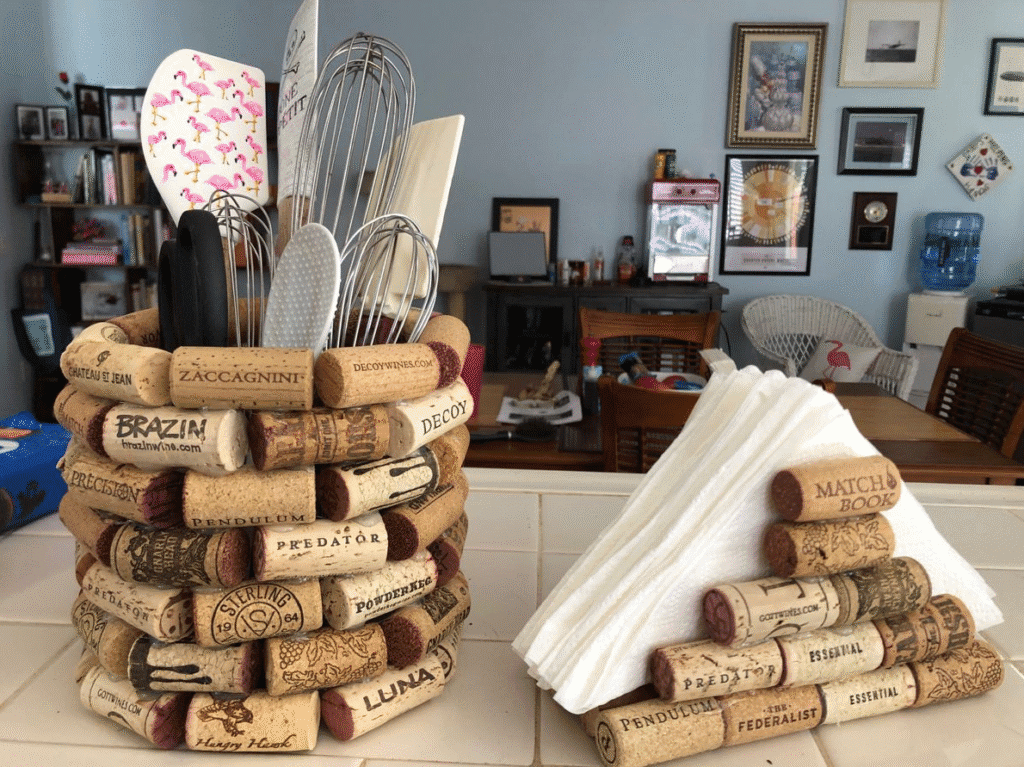 DIY wine cork utensil holder and napkin holder made from stacked corks on a kitchen counter