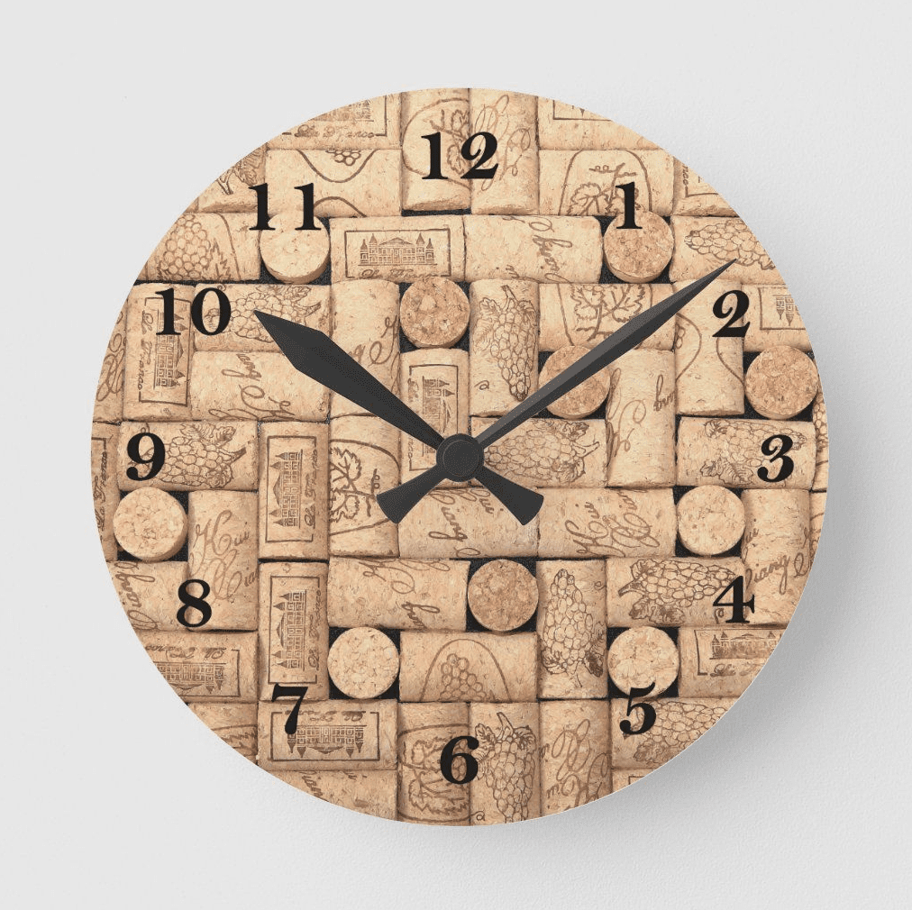 Round wall clock made from upcycled wine corks with black numbers and hands on a light background