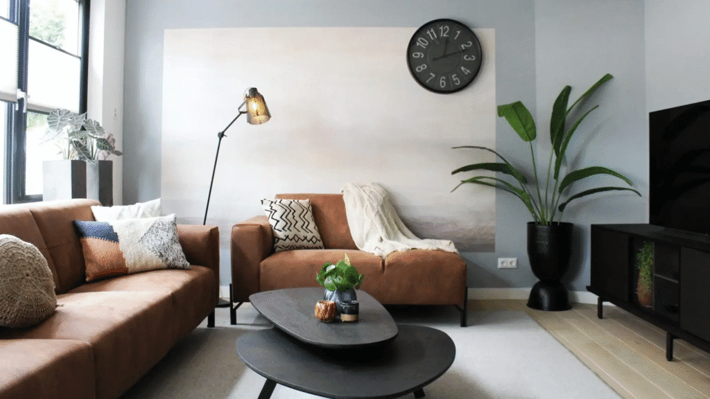 Modern living room with tan sofas, black coffee table, and green plants showcasing budget friendly home accents
