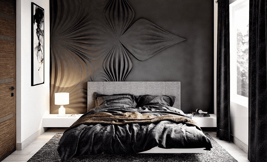 Moody bedroom with sculpted black accent wall, low gray bed, dark bedding, and soft lamp light creating a bold eclectic look